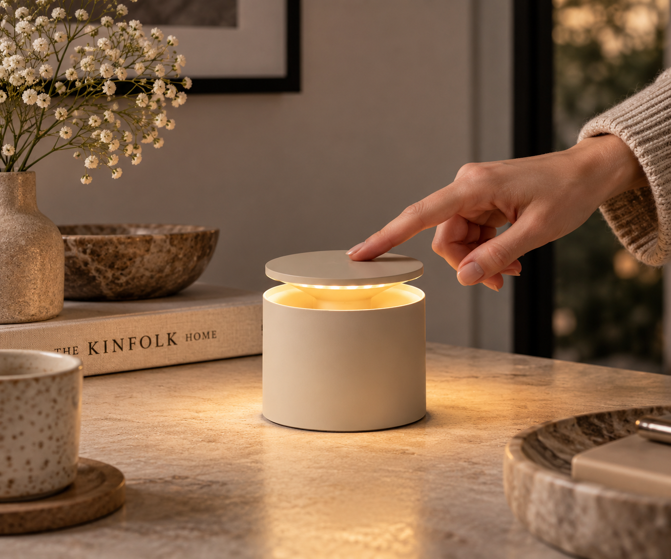 Kompakte Zafferano Push-Up Akku-Tischlampe in der Farbe Sand mit geöffnetem oberen Leuchtenteil und warm leuchtendem LED-Licht.